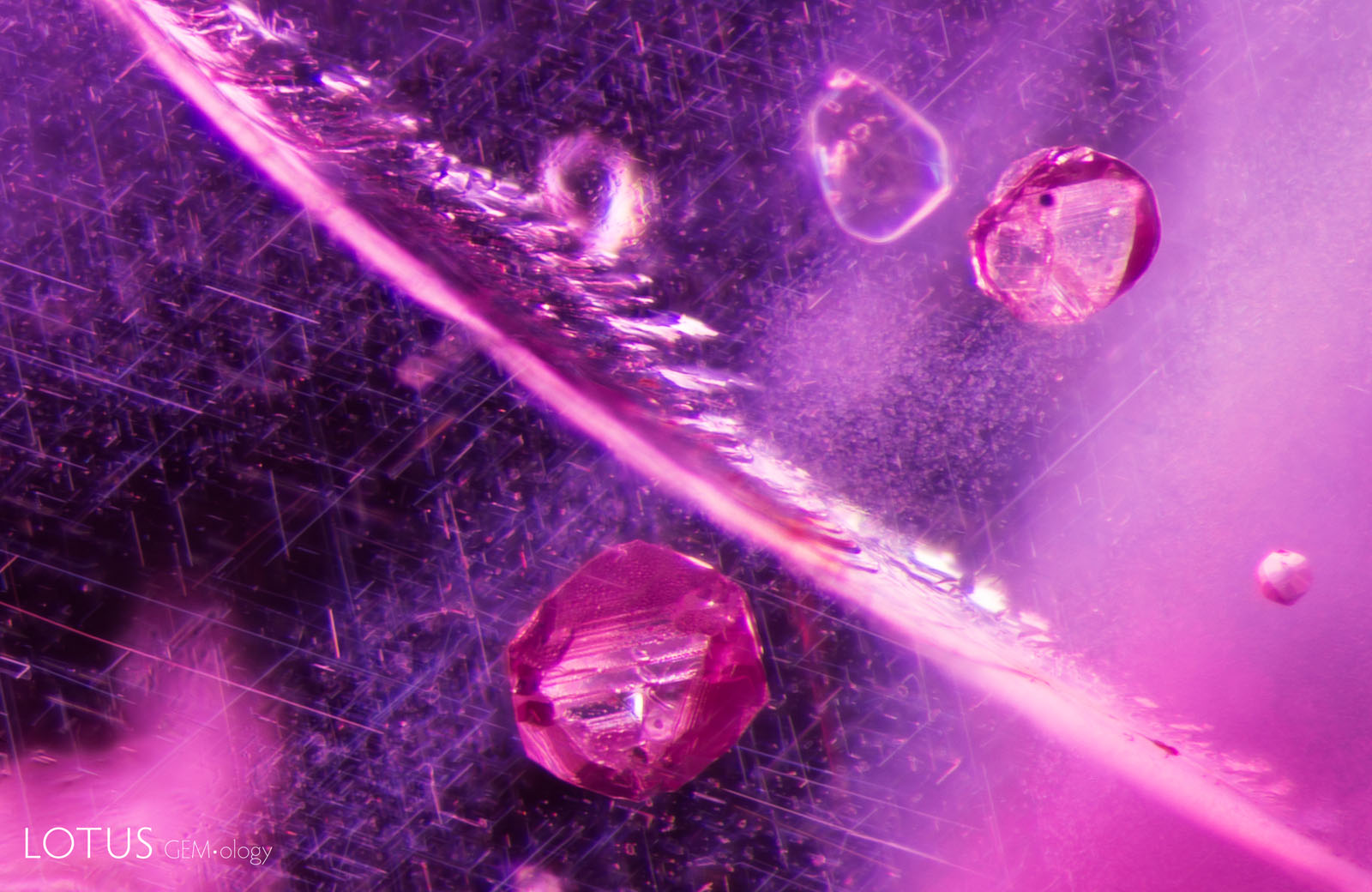(Unheated) Sample 18 contains a variety of interesting inclusions. On either side of this fissure are two angular sulfide crystals set against a background of rutile silk needles.