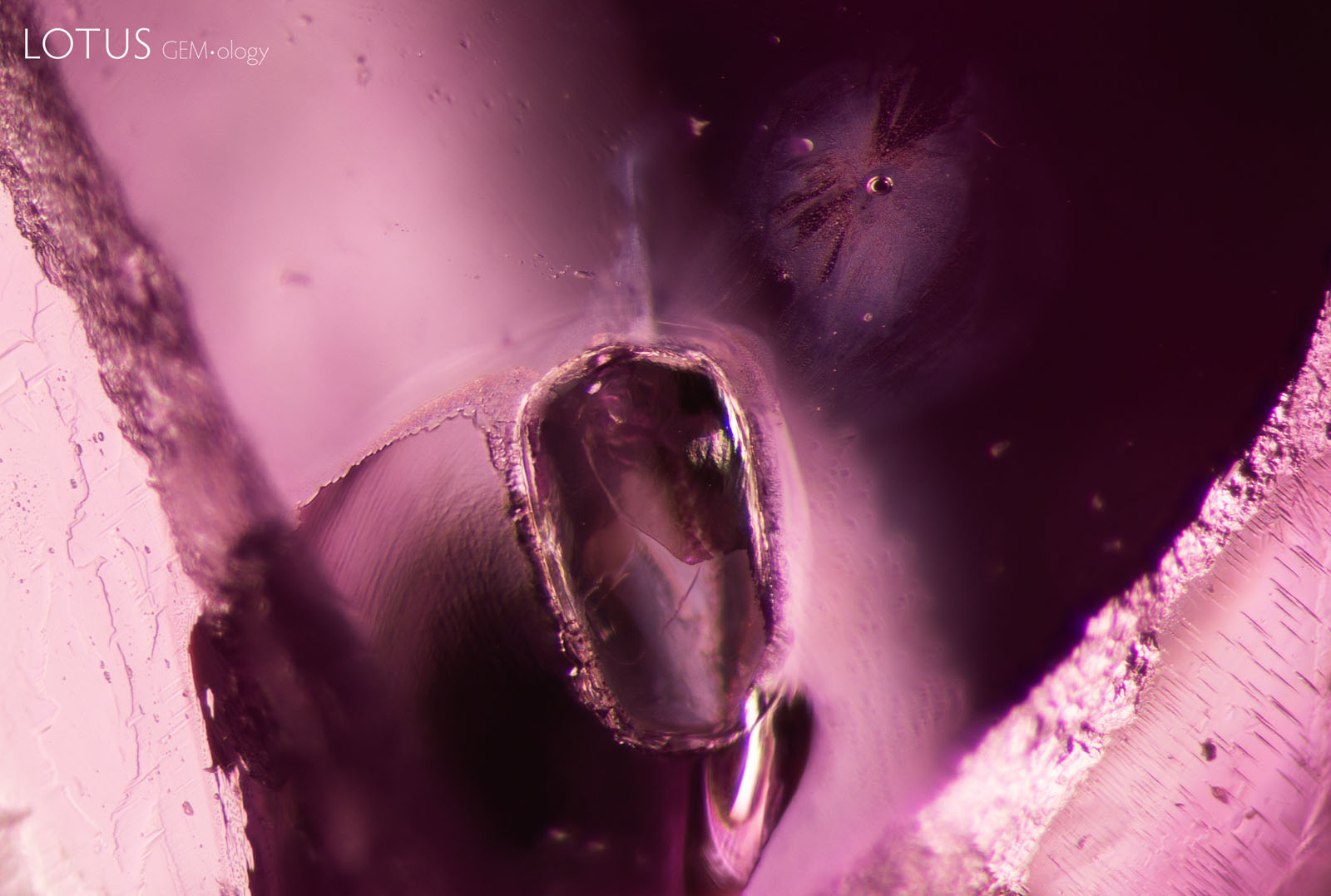 (1500°C) The fissures have expanded and appear cloudier. The larger crystal’s surface has altered, while the smaller crystal displays a more rounded, bubble-like appearance.