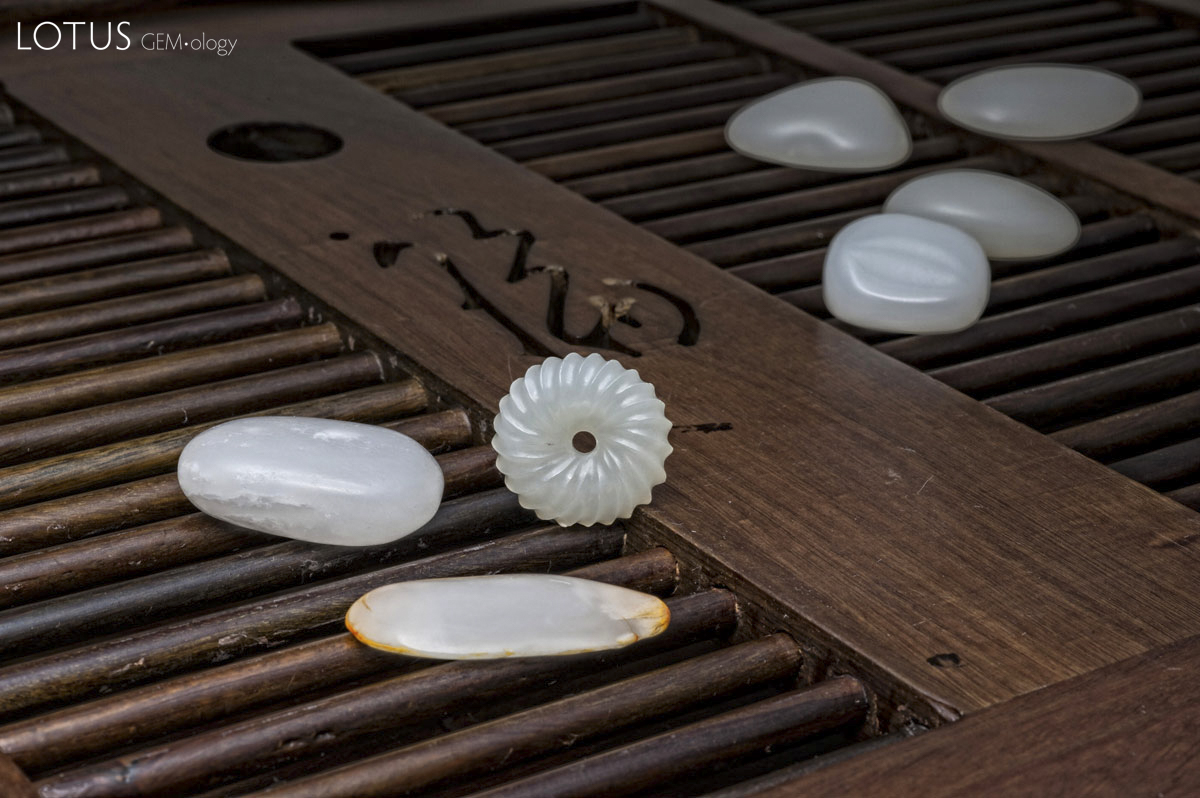 Figure 9. Seven pieces of what appears to be Chinese nephrite purchased in Guangzhou's Hualin Street jade market on 2 April 2012 by three of the authors (RWH, WM, ACM). The three pieces in the foreground proved to be genuine nephrite (most likely from Xinjiang), while the four in the background were clever imitations. Photo: Wimon Manorotkul.
