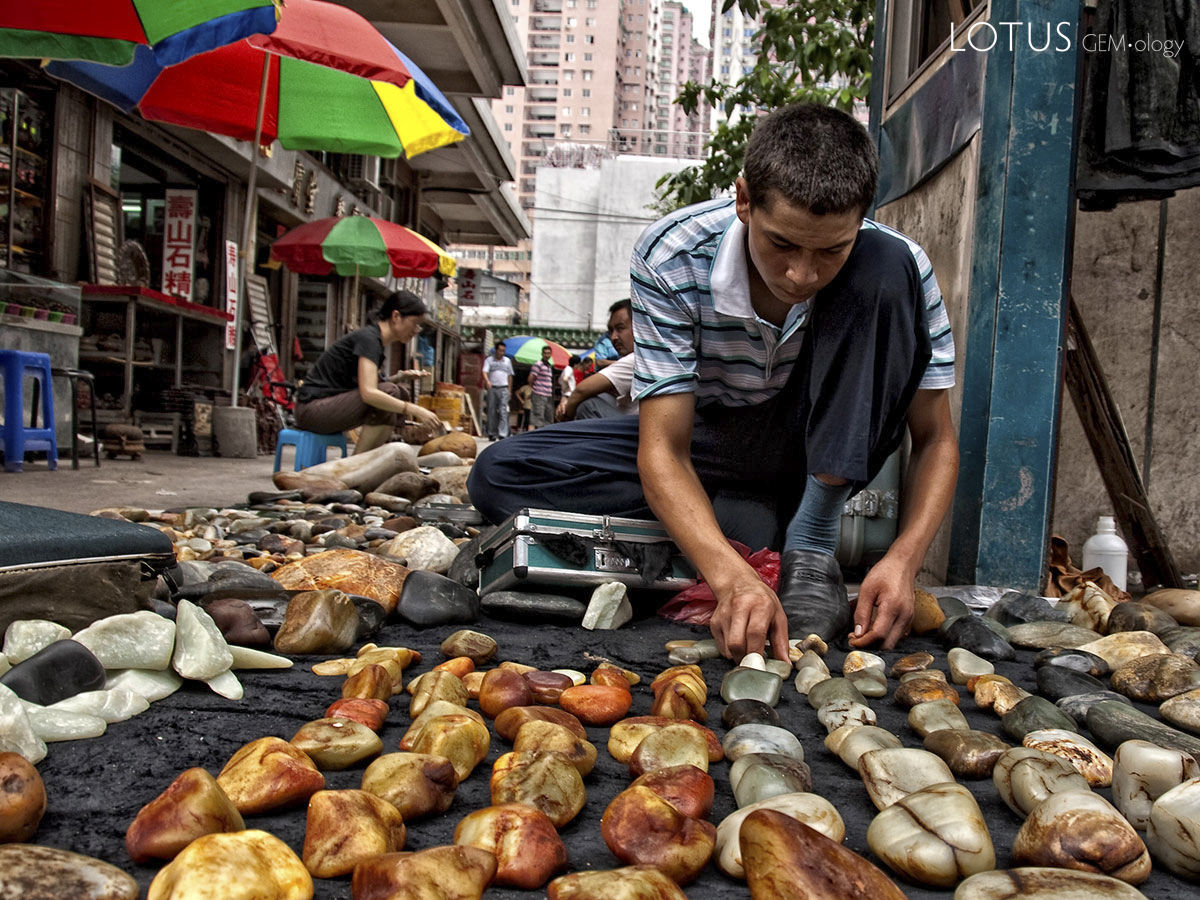Figure 4. A Uighur man lays out his wares in Guangzhou's Hualin Street jade market. China's nephrite mines are located near Hotan (aka Khotan, Hetien), in western China's Xinjiang province. Photo: Richard W. Hughes.