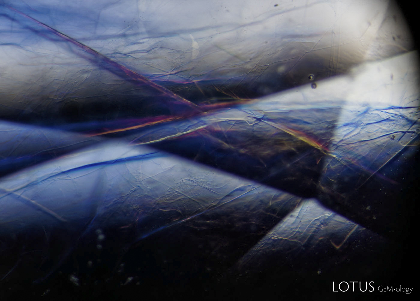 Figure 9. The lead-glass filler often produced a yellow/blue/pink flash effect as the stone was rotated in the microscope. Oblique fiber-optic illumination. Photo: Wimon Manorotkul