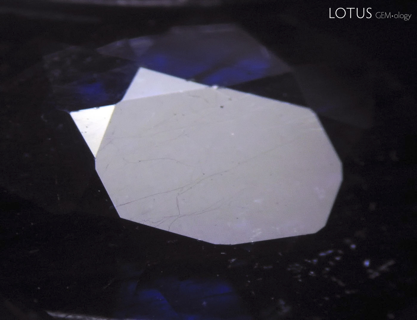 Figure 18. Table facet of one cobalt-doped glass-filled sapphire before (left) and after (right) heating with a jeweler&rsquo;s torch. (Photos: Thanong Leelawatanasuk).