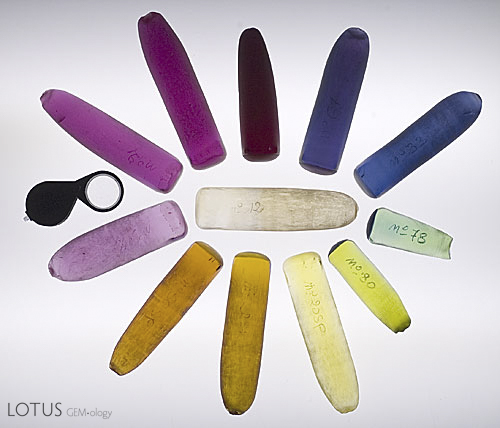 Figure 1. A selection of half boules grown by the Verneuil process, illustrating many of the colors these crystals are grown in. Due to stress in the growth process, a parting plane forms in all Verneuil grown synthetic corundums. Splitting boules along this plane prior to cutting relieves this stress. Photo &copy; Richard W. Hughes