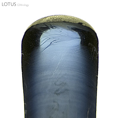 Figure 3. Curved banding as seen in a half boule of Verneuil synthetic corundum. Note that the curvature is greatest at the outside edges. Photo &copy; Richard W. Hughes