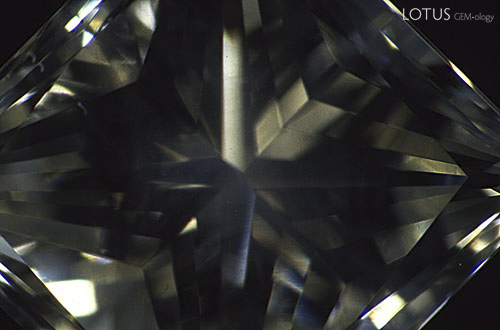 Figure 5. In darkfield illumination only a vague image of a cloud of pinpoint inclusions is visible in this pale green diamond. Magnified 10&times;. Photomicrograph &copy; John I. Koivula, microWorld of Gems.