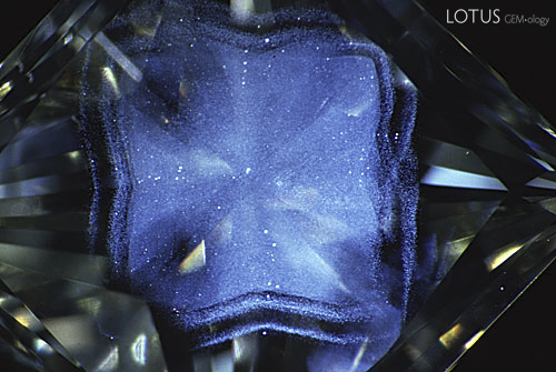 Figure 6. When fiber-optic illumination is used on this same green diamond, the details of an amazing phantom cloud become visible. How many significant features in diamonds have been overlooked because of inadequate darkfield lighting? Magnified 10&times;. Photomicrograph &copy; John I. Koivula, microWorld of Gems.