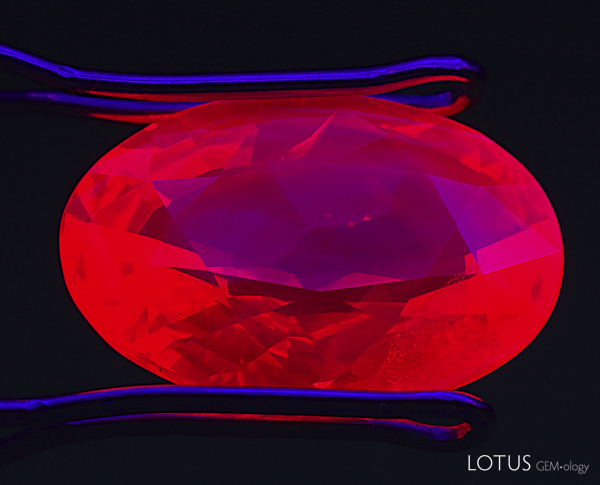 Figure 15. Let it glow In this heat-treated and flux-healed ruby from M&ouml;ng Hsu, Burma, thin zoned patches of chalky blue fluorescence float on top of the chromium-based red body fluorescence. These chalky blue zones are a strong indication of high-temperature heat treatment. SW UV. Photo: Richard W. Hughes; Nikon D70