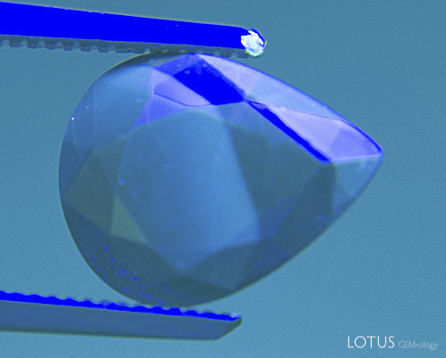 Figure 17. It&rsquo;s easy being green In the same stone from Figure 16, a green Schott BG-12 filter is placed over the gem. It removes the red fluorescence, thus making the chalky blue areas far easier to see. SW UV. Photo: Richard W. Hughes; Nikon D70