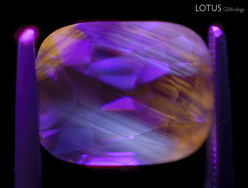 Figure 14. Zoned "apricot" orange LW fluorescence in an untreated Madagascar blue sapphire. Photo: Richard W. Hughes; Nikon D200