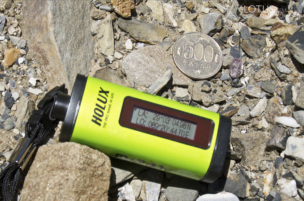 Figure 6. A "floater" of andesine just to the right of the coin in Upper Yu Lin Gu valley. Photo: Richard W. Hughes