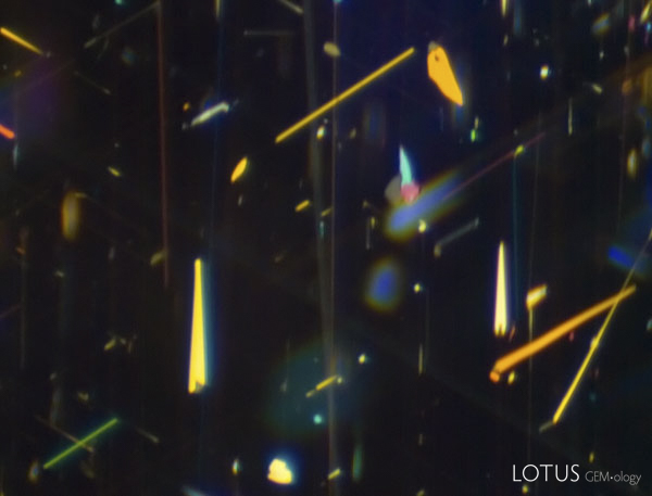 Again, tiny daughter crystals are clearly visible at the broad ends of rutile arrows in this untreated blue sapphire. Photo: Richard W. Hughes