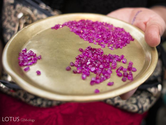 Rough ruby on a brass plate at the market in Mogok, Myanmar. The yellow color of the plate makes the ruby appear more red. Photo: R.W. Hughes, 2013