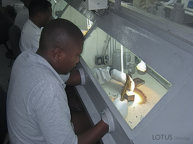 Sorters cobbing rough at TanzaniteOne's sorting room. Women previously did this job, but after one was found secreting gems in a body cavity and a general search of the room turned up over seven kilos of rough hidden in caches of both the human and man-made kind, the job was given over to men. Today, the overseeing is performed by ex-Gurkha soldiers from Nepal. Photo: Richard W. Hughes