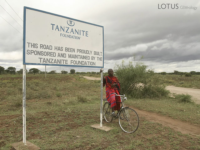 A Masai next to the sign and road to Merelani. Photo: Tanzanite Foundation