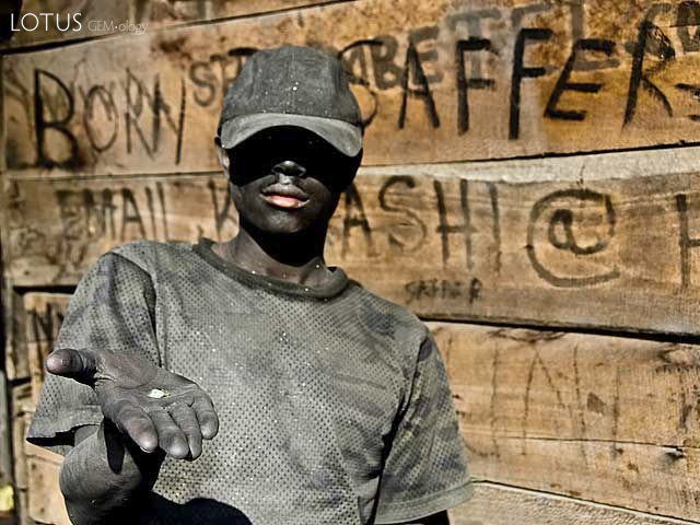Born to Saffer A graphite-coated tanzanite miner sparkles in the sun at Merelani's Block D, a small fragment of pale green diopside his only reward for six hours underground. Photo: Richard W. Hughes
