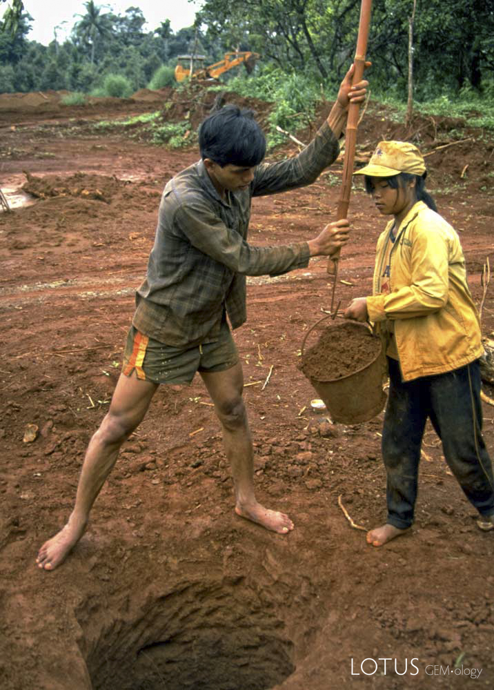 Pit miners at Khao Ploi Waen, ca. 1980. While the mine was real, the cut stones being sold just off camera were anything but, consisting of doublets made of thin slices of natural green sapphire on top of Verneuil synthetic corundum.&nbsp;Photo: Richard W. Hughes
