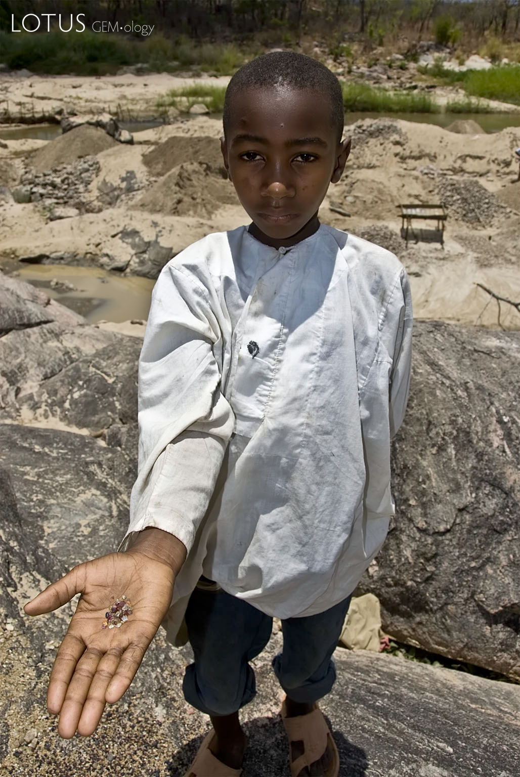 River of dreams A young boy along the Muhuwesi River with a handful of gems. Photo: Richard W. Hughes