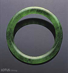 Figure 26. Believed to date back at least four millennia in China, the jade bangle is both one of the oldest and one of the most important pieces of jewelry in the Chinese culture. This superb jadeite bangle sold for US$2,576,600 at the Christie's Hong Kong November 1999 auction. The interior diameter is 49.50 mm; the jadeite is 8.36 mm thick. Photo courtesy of and &copy; Christie's Hong Kong and Tino Hammid.