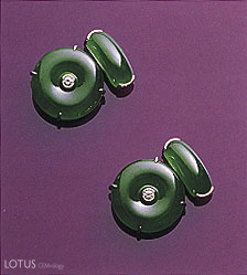 Figure 7.&nbsp;These fine matched&nbsp;huaigu&nbsp;(each approximately 19 x 4.5 mm) have been set as cufflinks, with diamonds inserted into their center holes. Each is linked to a saddle top of comparable material. Photo courtesy of and &copy; Christie's Hong Kong and Tino Hammid.