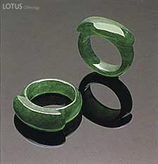 Figure 8. Note the small patches of a slightly paler color on the shank of one of these "emerald" green saddle rings (21.27 and 21.65 mm, respectively, in longest dimension). Photo courtesy of and &copy; Christie's Hong Kong and Tino Hammid.
