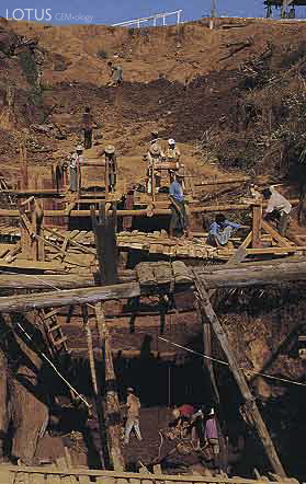 Figure 5. In some areas at Tawmaw, miners must dig deep shafts through the overburden to reach the jadeite dikes. Dirt and gravel are removed by a rudimentary winch-and-bucket system. Photo &copy; 2000 Fred Ward.