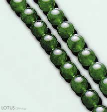 Figure B-2. Jadeite jade typically contains at least 90% jadeitic pyroxene in a rock that is typically more granular than nephrite. Note the vitreous surface luster of these translucent jadeite beads, which range from 9 to 10.5 mm in diameter. Photo courtesy of and &copy; Christie's Hong Kong and Tino Hammid.