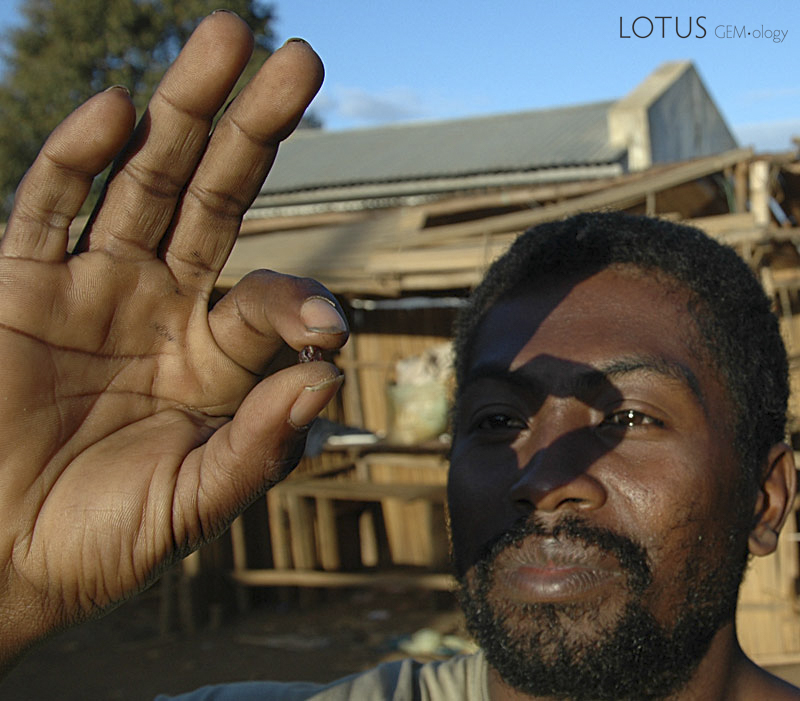 A miner examines a piece of ruby rough in Andilamena&rsquo;s market. Photo: Richard W. Hughes