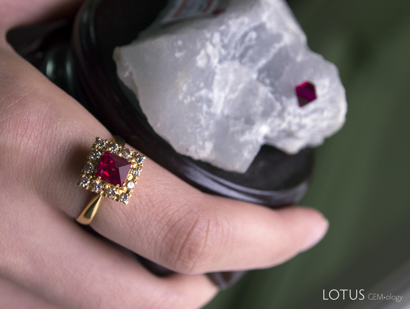 Figure 4. Ruby is not the only gem found in marble at Mogok. Spectacular red spinels are even more common. Some of these octahedral crystals are so perfect that they are termed nat-twe (angel polished). The photo shows a completely natural spinel crystal mounted in a ring, along with a natural spinel octahedron in the marble mother rock. Specimens courtesy of Dr. Saw Naung U family; Photo: Wimon Manorotkul
