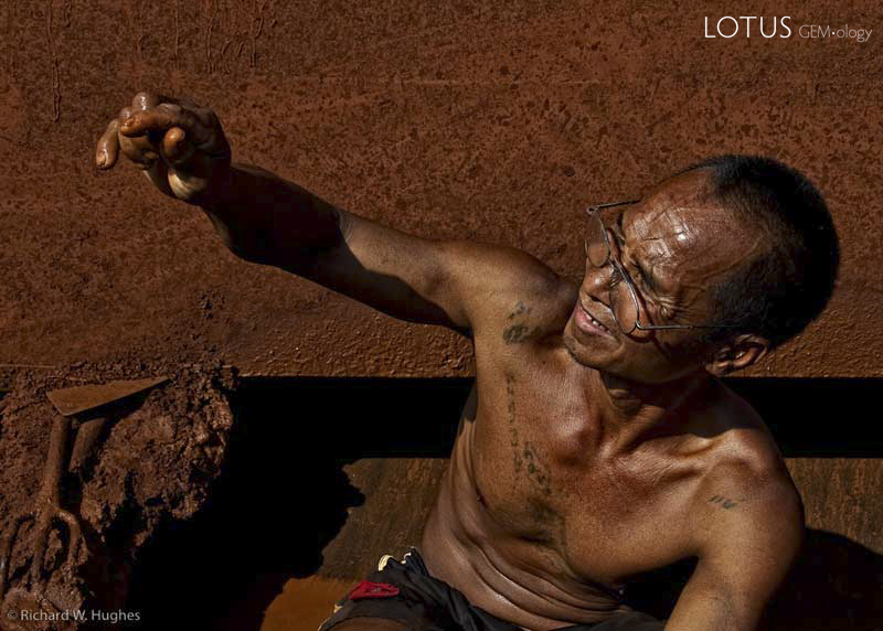 One of the last remaining sapphire miners at Khao Ploi Waen examines a find. Photo: Richard W. Hughes, February 2009.