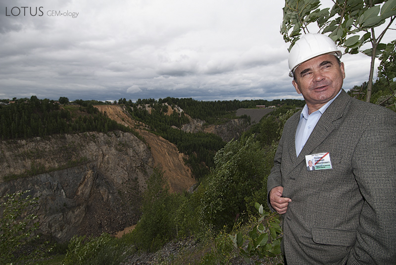 Top:&nbsp;The small village of Malysheva, perches on the very edge of the large open trench (just beyond the trees in the background). Photo: Warren Boyd  Bottom: Evgeny Nikolayevich Kazeyev, then of Zelen Kamen (ZK), standing above the large open trench at Malysheva. This pit was created and mined from 1956&ndash;1971. Photo: Richard W. Hughes