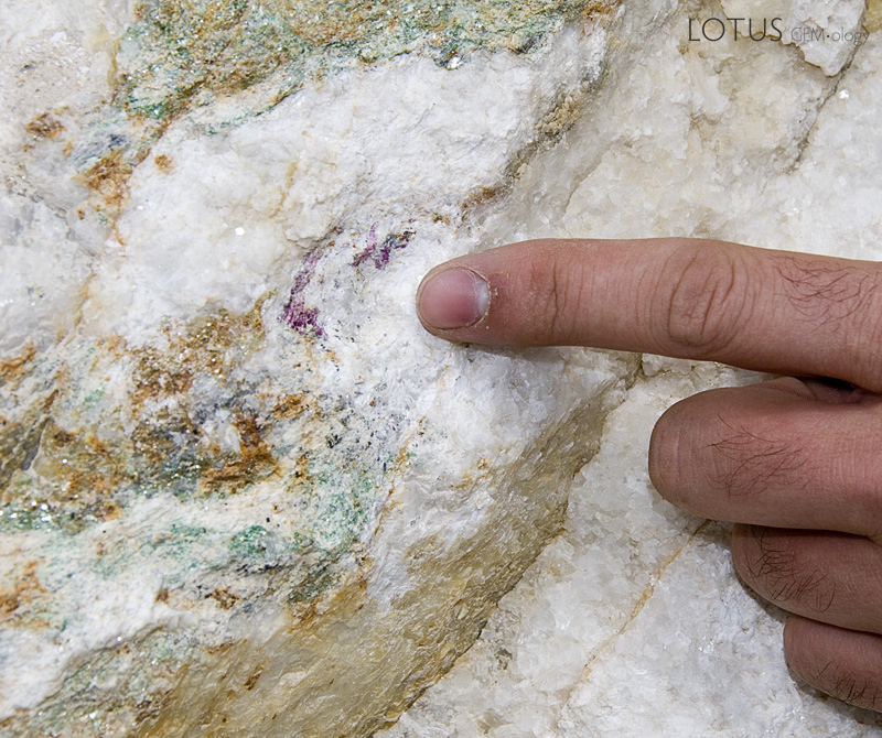 Flecks of red ruby and green fuchsite mica are seen in the marble matrix at the Snezhny ruby mines in eastern Badakhshan. Photo: Richard W. Hughes
